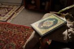 No people high angle of holy Quran book in green hard cover decorated with gold ornaments lying in living room